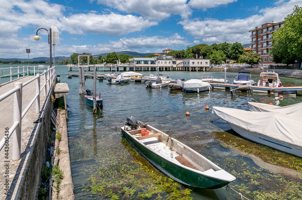 Boats moored in the water in front of the center of Passignano sul Trasimeno, Umbria, Italy