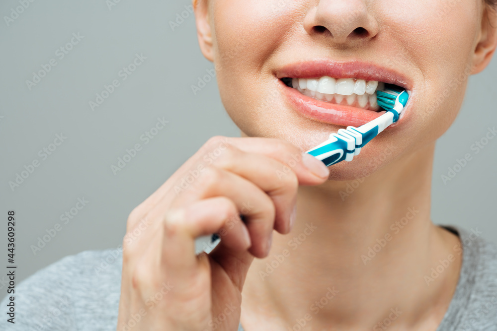 Woman with healthy white teeth holds a toothbrush and smiles. Oral hygiene concept Woman with healthy white teeth holds a toothbrush and smiles. Oral hygiene concept