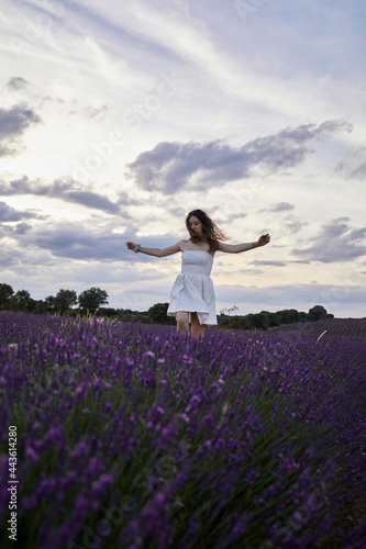 Woman in a white dress walks and has fun in the lavender fields