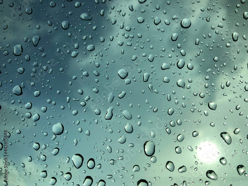 Raindrops on a window with a blue sky