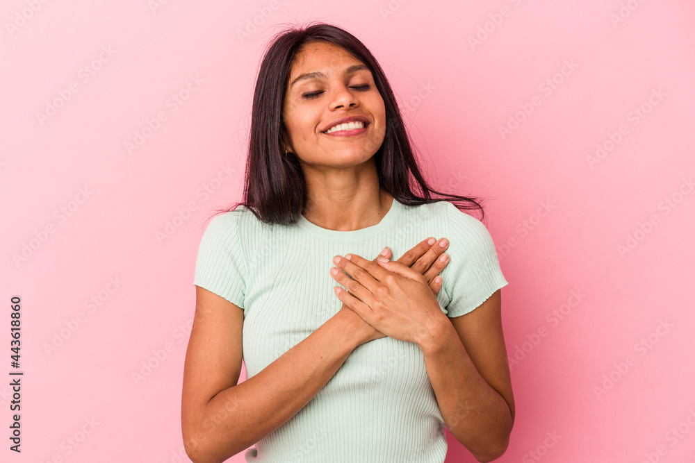 Young latin woman isolated on pink background laughing keeping hands on heart, concept of happiness. Young latin woman isolated on pink background laughing keeping hands on heart, concept of happiness.