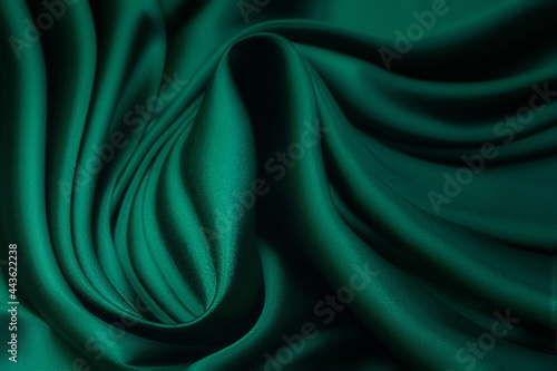Texture, background, pattern. Texture of green silk fabric. Beautiful emerald green soft silk fabric.