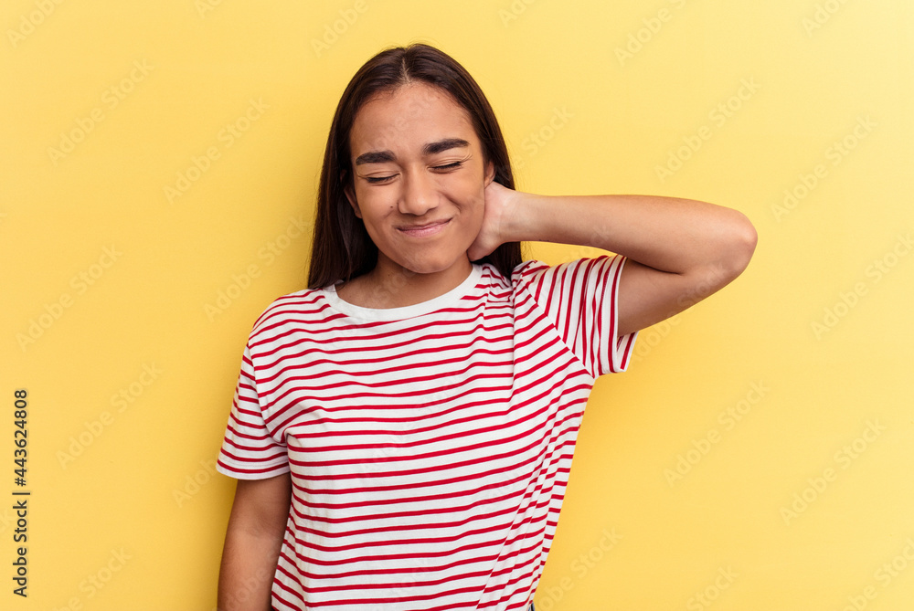 Young mixed race woman isolated on yellow background having a neck pain due to stress, massaging and touching it with hand. Young mixed race woman isolated on yellow background having a neck pain due to stress, massaging and touching it with hand.