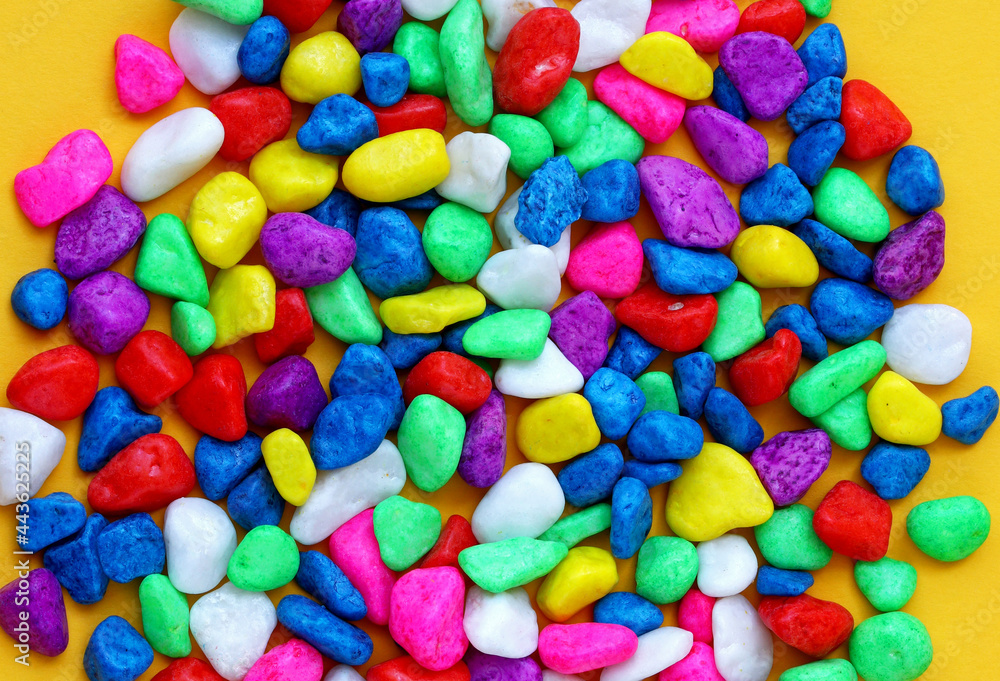 colored pebbles on yellow background colored pebbles on yellow background