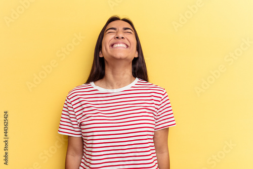 Young mixed race woman isolated on yellow background relaxed and happy laughing, neck stretched showing teeth.