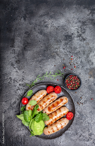 Grilled sausage with spinach, avocado and cherry tomato. hot barbecue dish. Keto paleo diet menu. vertical image. top view. place for text photo