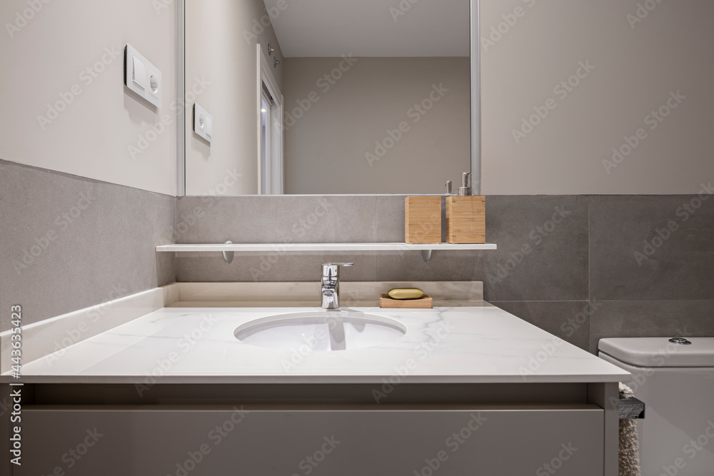 Fototapeta premium Sink with white marble countertop and tiles, paint and gray furniture