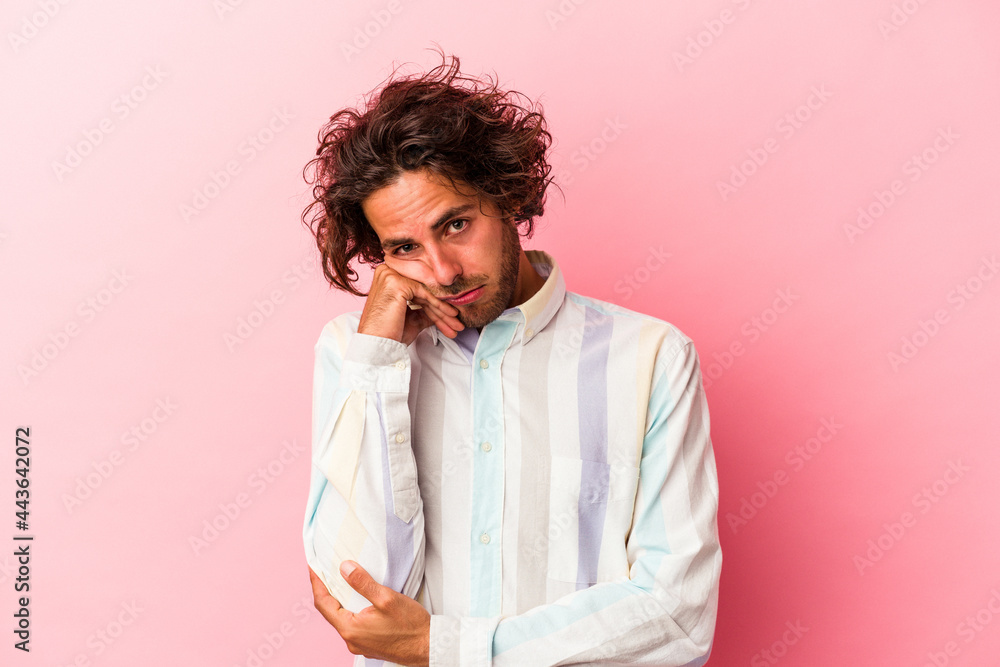 Young caucasian man isolated on pink bakcground tired of a repetitive task. Young caucasian man isolated on pink bakcground tired of a repetitive task.