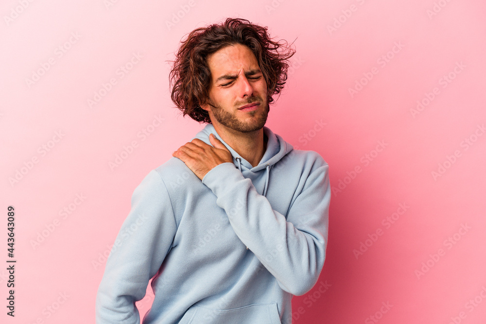 Fototapeta premium Young caucasian man isolated on pink bakcground having a shoulder pain.