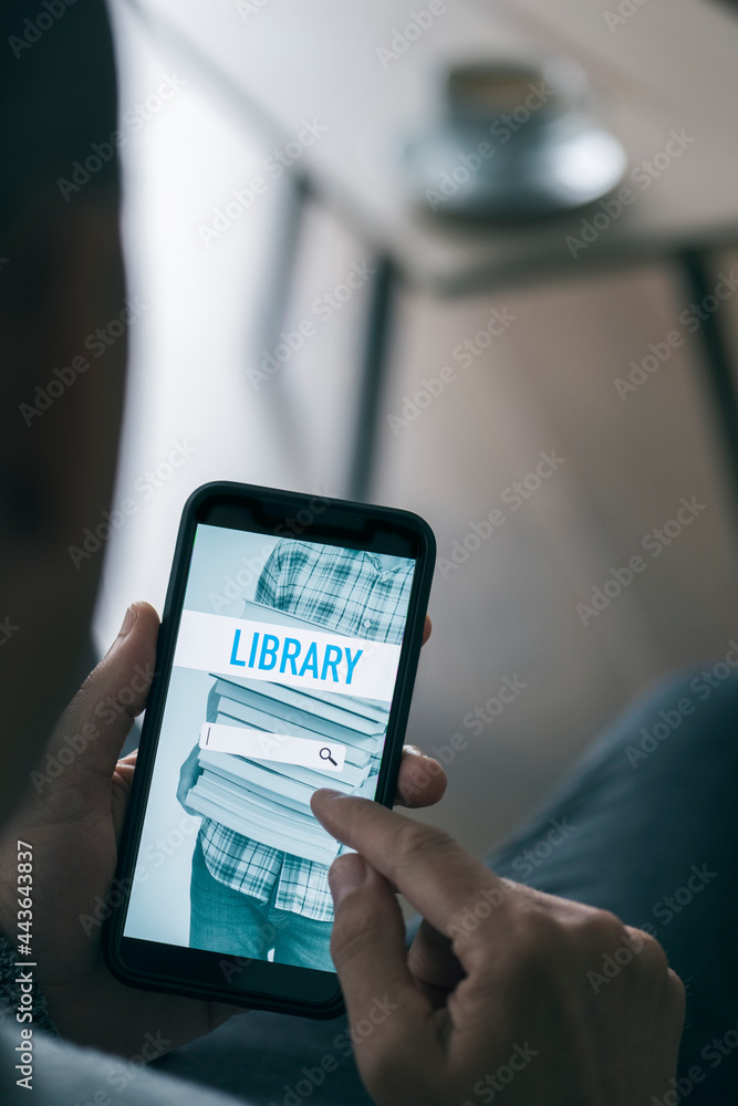 is searching on an online library with his phone