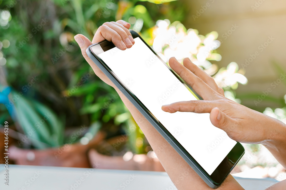 Woman's hand is touching on the white screen of the tablet, using ...