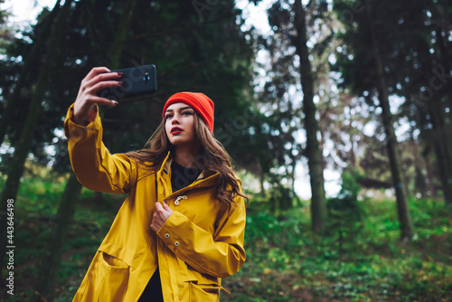 Charming woman taking selfie hiking in forest
