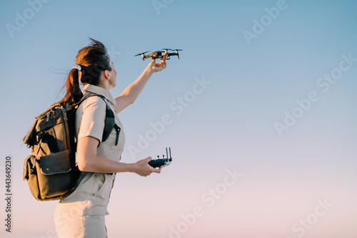 Drone launch. Young woman tourist holds a drone in his hand lifting it up. Selective focus.