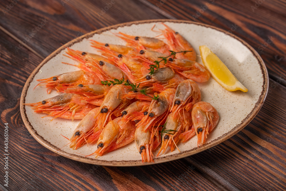 Beautifully laid out boiled tiger prawns on a plate with lemon slices and spices Beautifully laid out boiled tiger prawns on a plate with lemon slices and spices