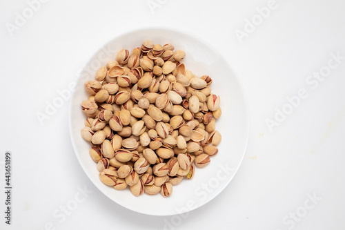 Pistachios nuts in white bowl top view