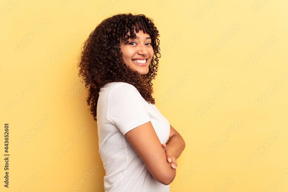 Young mixed race woman isolated on yellow background happy, smiling and cheerful. Young mixed race woman isolated on yellow background happy, smiling and cheerful.