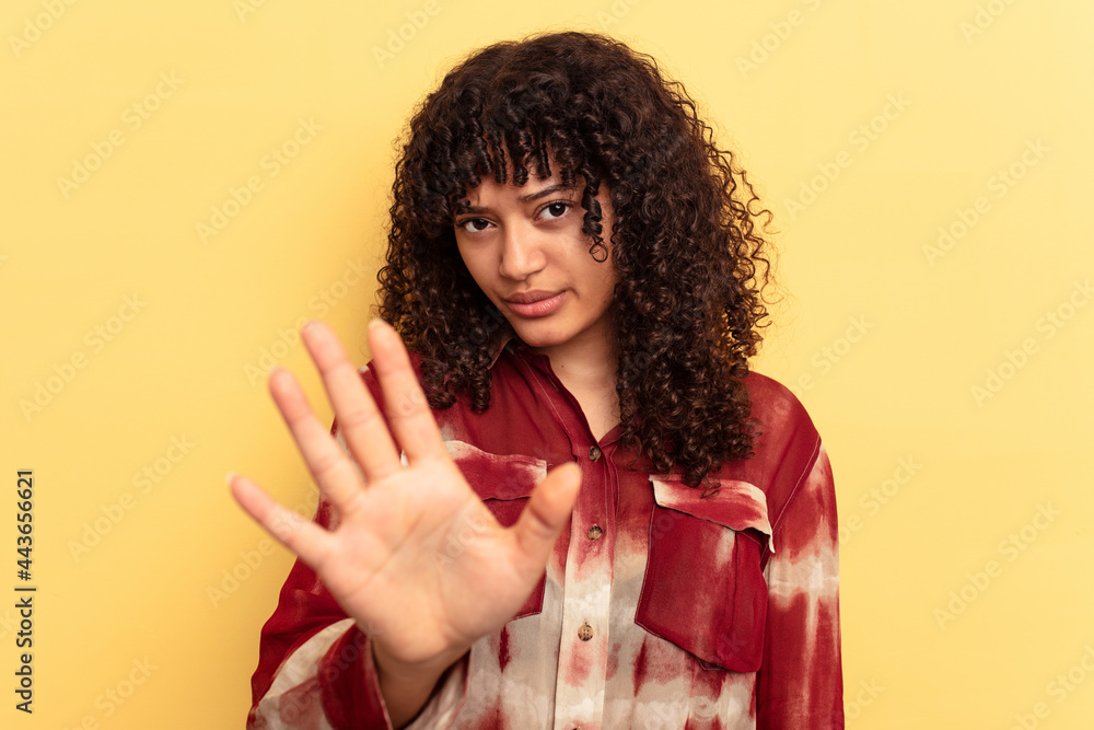 Young mixed race woman isolated on yellow background rejecting someone showing a gesture of disgust. Young mixed race woman isolated on yellow background rejecting someone showing a gesture of disgust.