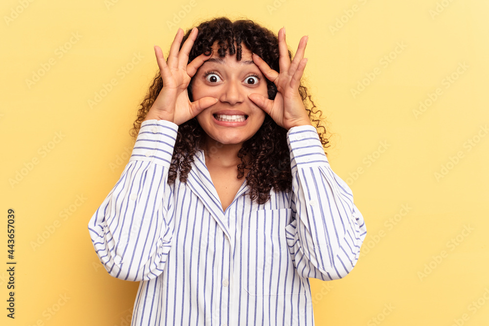 Young mixed race woman isolated on yellow background keeping eyes opened to find a success opportunity. Young mixed race woman isolated on yellow background keeping eyes opened to find a success opportunity.