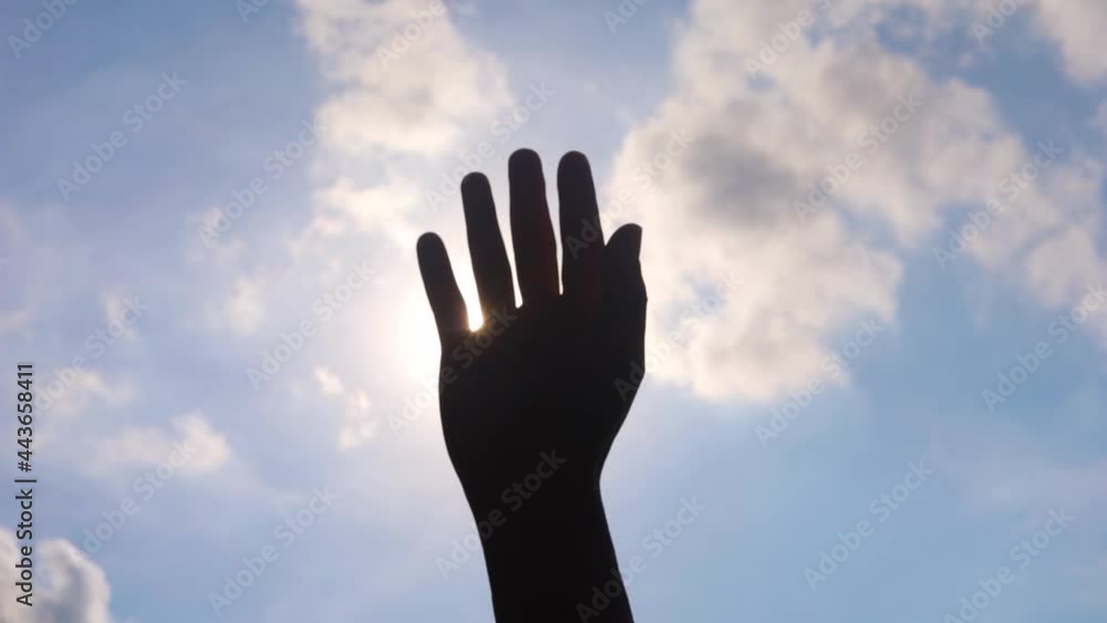 Close up of man hands playing hand with the sun light on the blue sky background. Close up of man hands playing hand with the sun light on the blue sky background.