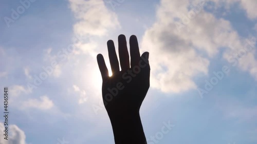 Close up of man hands playing  hand with the sun light on the blue sky background.