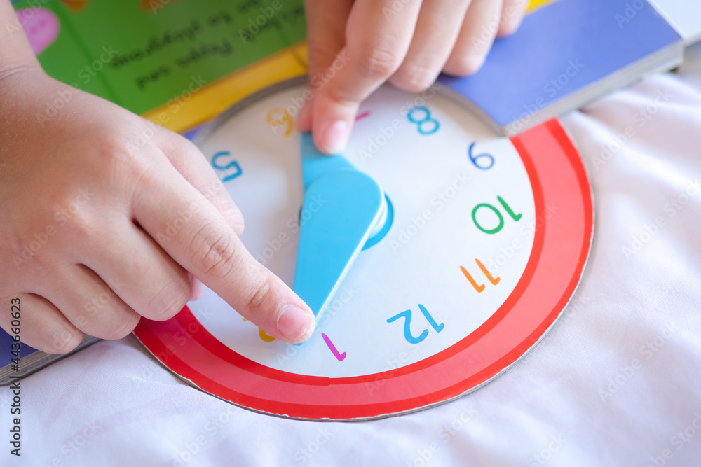 kid play telling time game, young children to learn how to read an