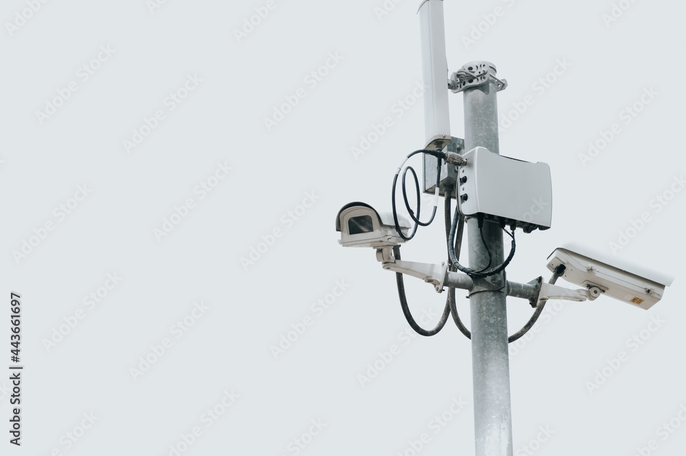 CCTV camera electric pole on isolated white sky with copy space. Safe and secure technology outside property and homeowner concept. Security card device and gadget theme. Outdoor electronic CCTV camera electric pole on isolated white sky with copy space. Safe and secure technology outside property and homeowner concept. Security card device and gadget theme. Outdoor electronic