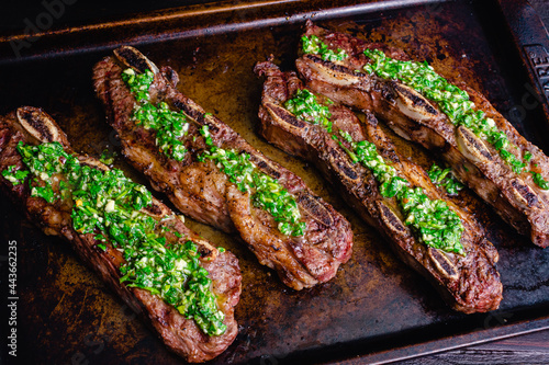 Argentinean-Style Grilled Short Ribs With Chimichurri: Barbecued flanken beef ribs topped with chimichurri sauce photo