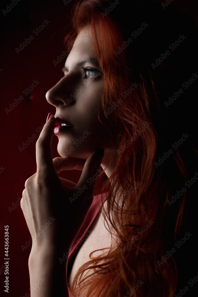 redhead woman, girl in a dark key, sexy and painted red lips redhead woman, girl in a dark key, sexy and painted red lips