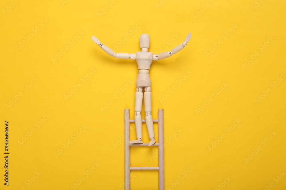 Wooden puppet climbs up the stairs on yellow background. Career growth concept Wooden puppet climbs up the stairs on yellow background. Career growth concept