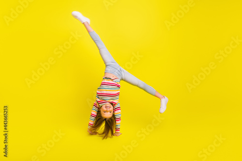 Fotografia Full length photo of happy flexible little girl enjoy active weekend upside down