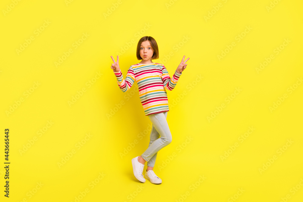 Full size photo of charming nice happy small girl send air kiss make v-signs isolated on yellow color background