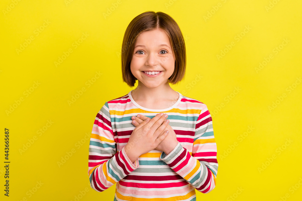 Photo of lovely short hairdo small girl hands heart wear colorful shirt isolated on vivid yellow color background Photo of lovely short hairdo small girl hands heart wear colorful shirt isolated on vivid yellow color background