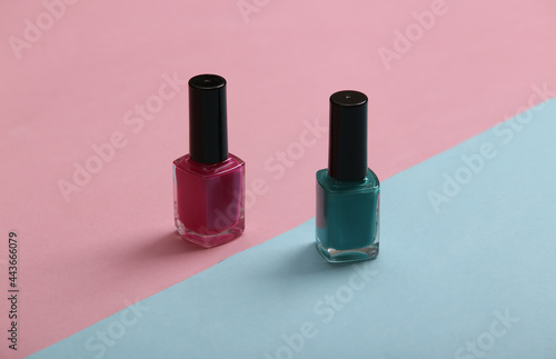 blue and pink nail polish bottles on a pastel background. Beauty still life © splitov27