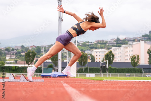 Athletic woman starting sprint at stadium