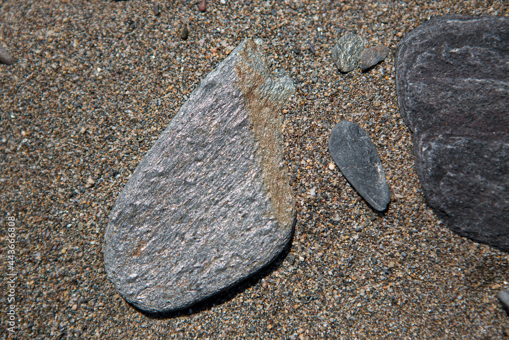 Photograph of sand and stones taken close up which makes an excellent background or texture.