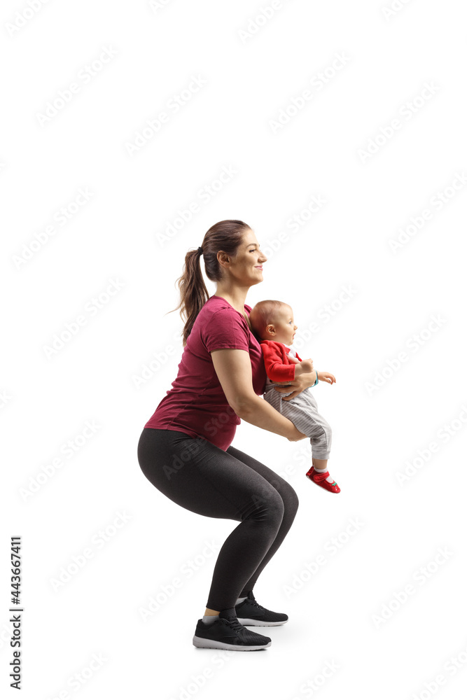 Full length profile shot of a mother exercising squats with a baby Full length profile shot of a mother exercising squats with a baby