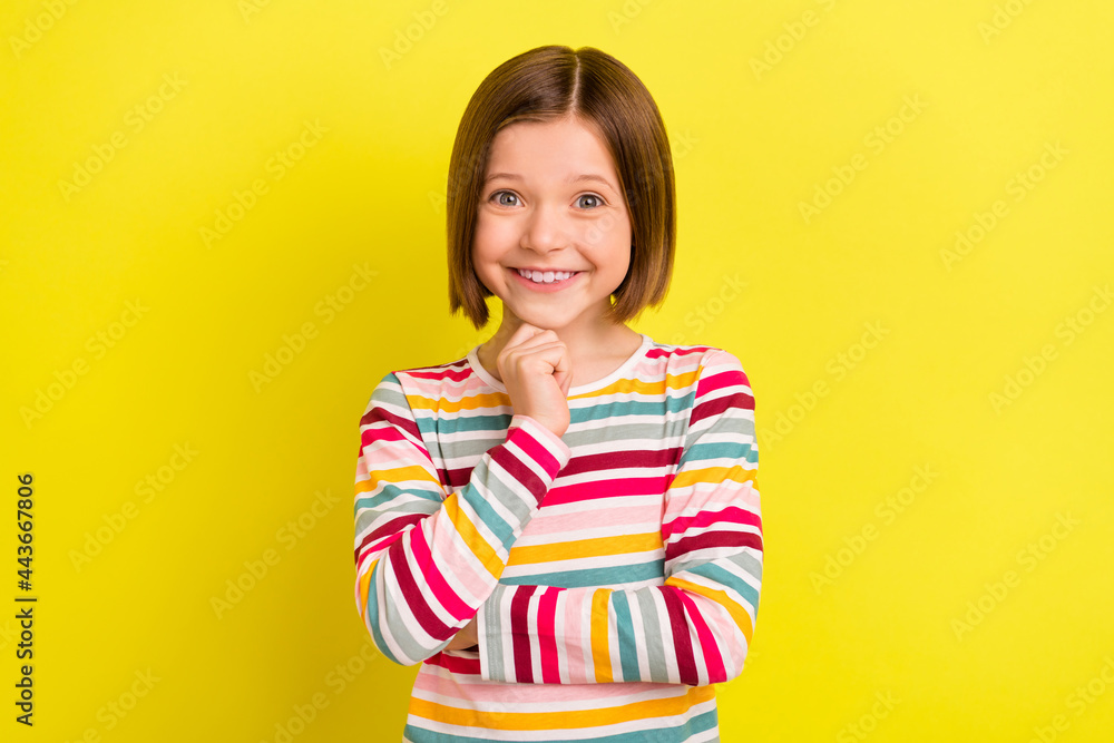 Photo of charming positive minded small gigl hold hand face chin isolated on shine yellow color background Photo of charming positive minded small gigl hold hand face chin isolated on shine yellow color background