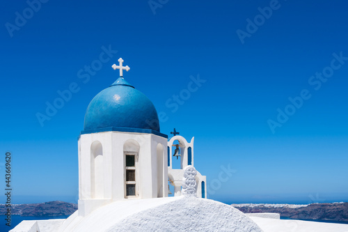 White and blue bell tower of the traditional Greek Orthodox church on the island of Santorini. Blue sky on background.