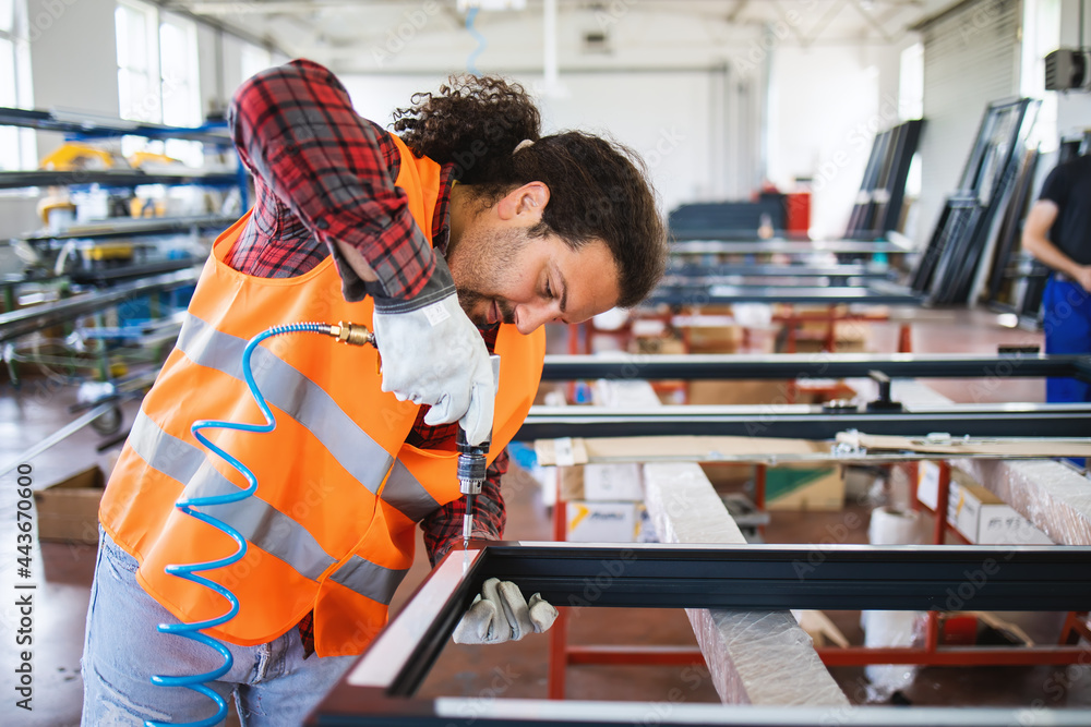 Manual worker assembling PVC doors and windows. Factory for aluminum and PVC windows and doors production.