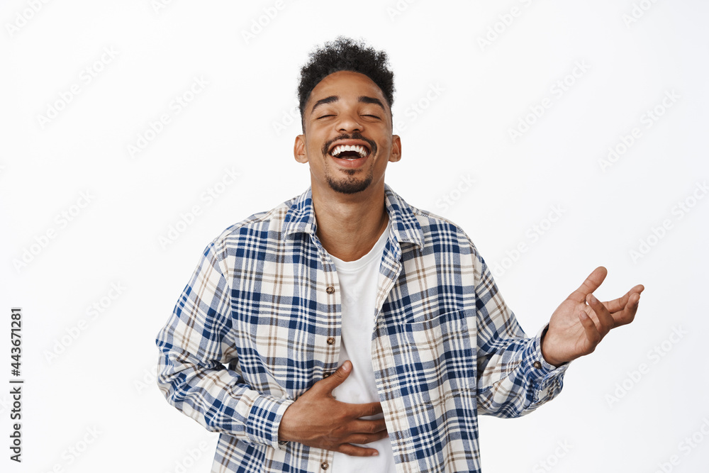 Happy african american guy laughing out loud, watching smth funny ...