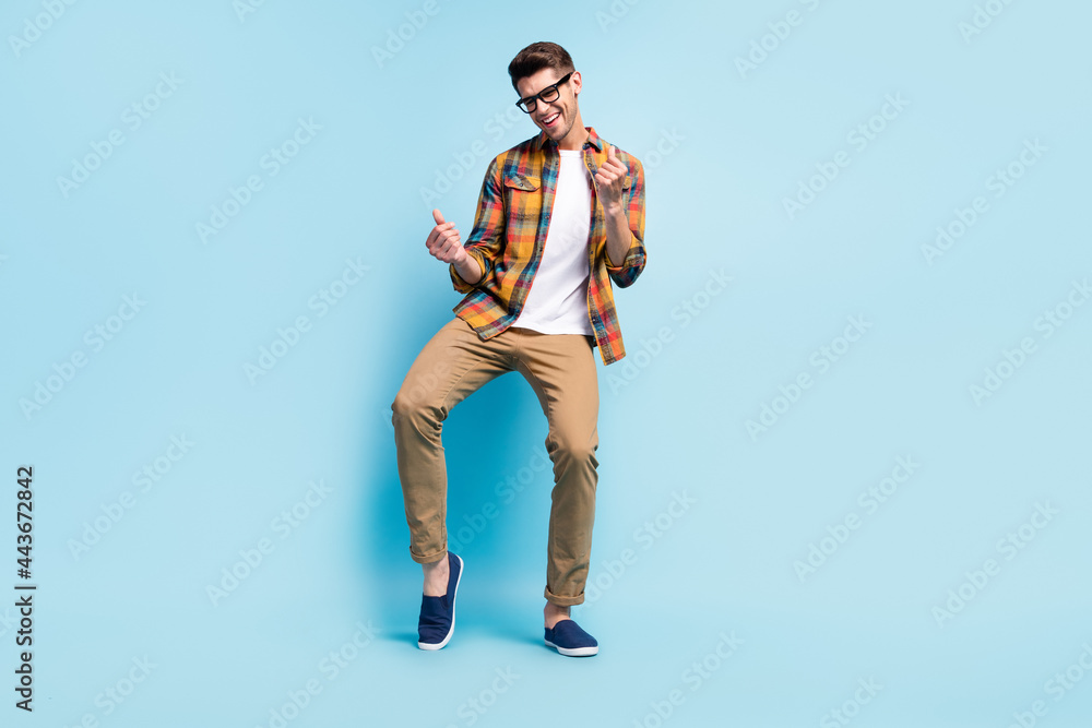 Photo of pretty adorable young gentleman wear checkered shirt dancing smiling isolated blue color background Photo of pretty adorable young gentleman wear checkered shirt dancing smiling isolated blue color background