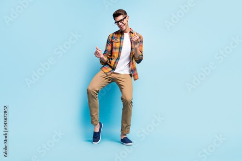 Photo of pretty adorable young gentleman wear checkered shirt dancing smiling isolated blue color background