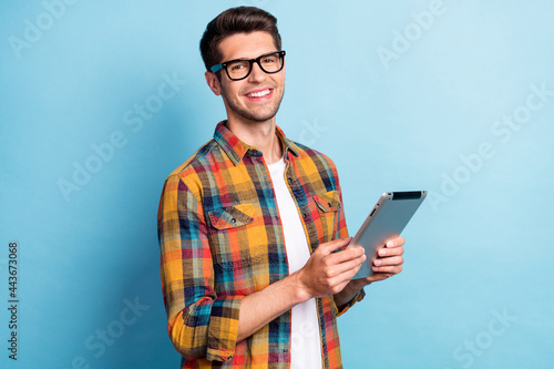 Portrait of attractive cheerful guy geek using device app 5g searching web isolated over bright blue color background photo
