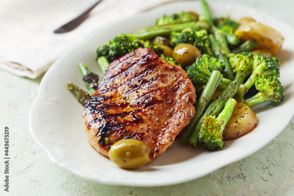 Grilled Turkey Breast with oven baked potatoes and broccoli. Bright wooden background. Close up. Grilled Turkey Breast with oven baked potatoes and broccoli. Bright wooden background. Close up.