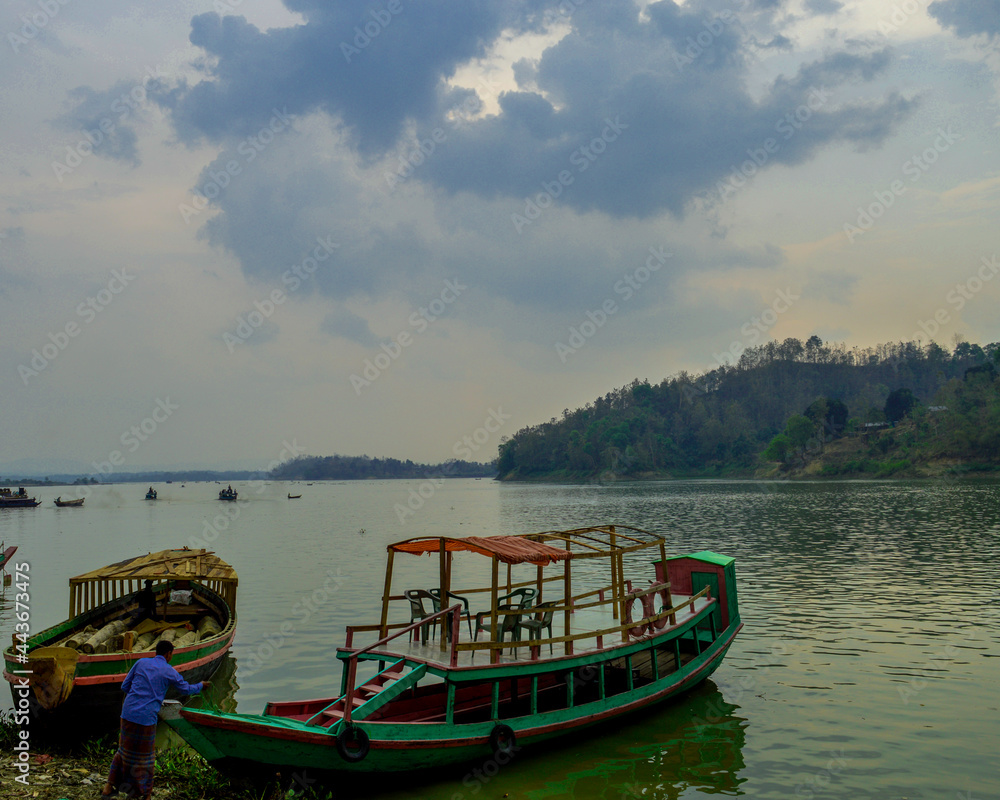 Boat in kaptai lake with beautyfil sky and green background
