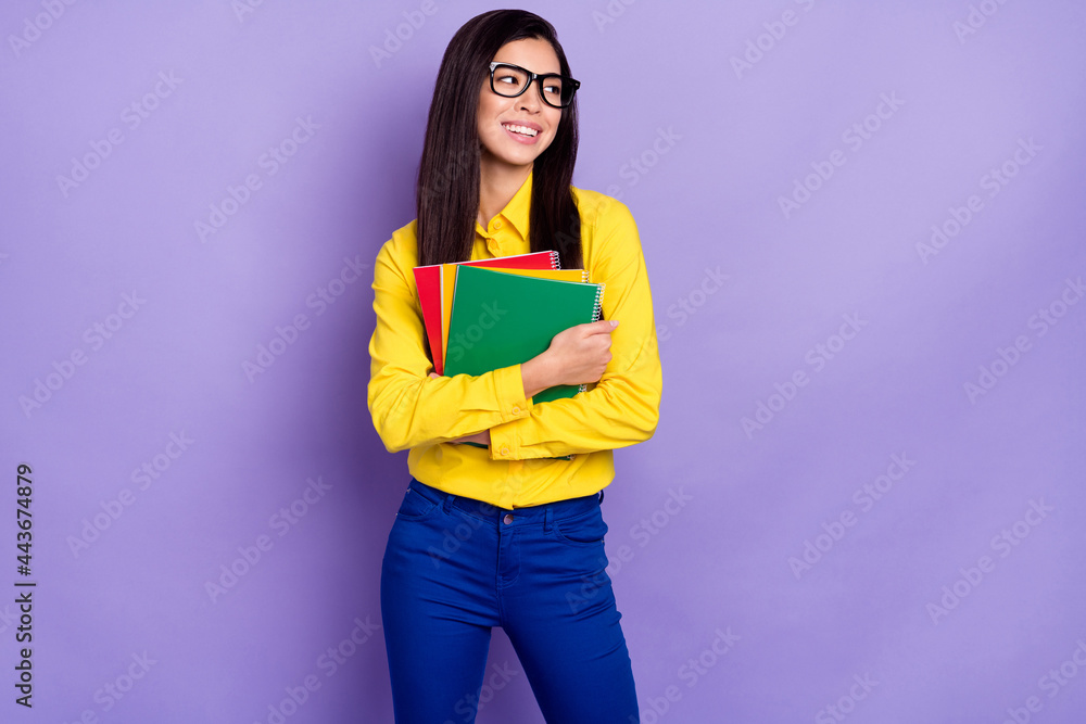 Fototapeta premium Photo of dreamy young attractive happy lady look empty space hold hands textbooks isolated on violet color background