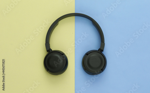 Black stereo headphones on colored pastel background. Top view