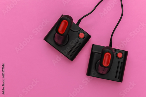 Two retro joysticks on pink background. Gaming, video game competition. Top view, minimalism