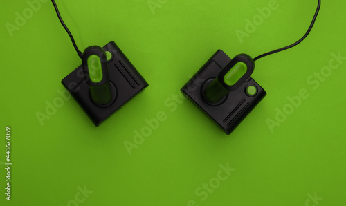 Retro joysticks on green background. Gaming, video game competition. Top view