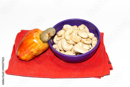 cashew nuts in bowl with cashew apple isolated on white background
